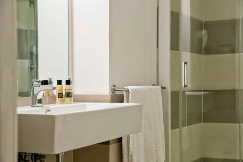 a bathroom with a white sink and a mirror at Domus Dejana in Gallipoli