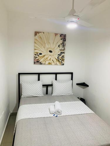 a bed with two white towels on top of it at Plata View Center Habitacion 2D in Monte Plata