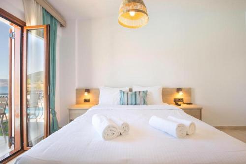 a bedroom with a white bed with towels on it at Sami Beach Hotel in Sami