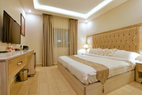 a hotel room with a large bed and a television at Petra Premium Inn in Wadi Musa
