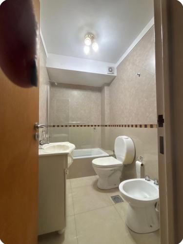 a bathroom with a toilet and a sink and a tub at Ballester apart piscina in Villa Ballester