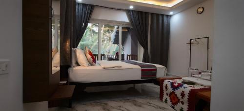a bedroom with a bed and a window and a sink at Hilias Retreat in Palolem