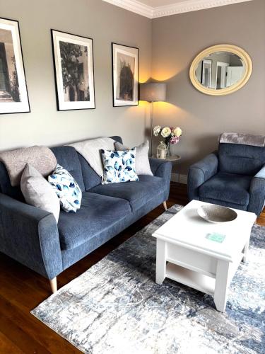 a living room with a blue couch and a table at Carraig House in Cavan