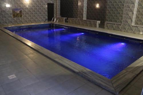 a swimming pool with blue lighting in a building at Jadara view in Irbid