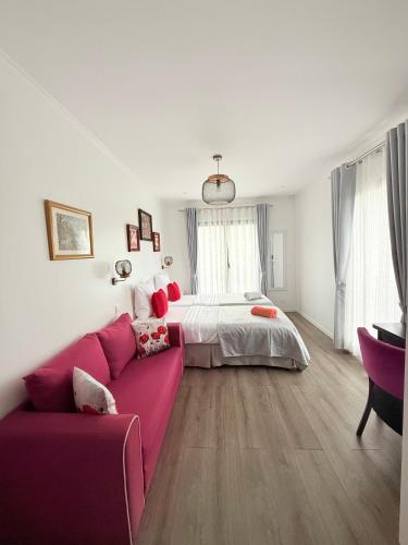 a living room with a pink couch and a bed at Paris Dream Villa in Villejuif