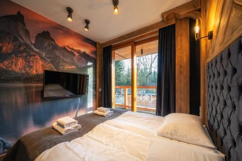 a bedroom with a large bed with two towels at Mountain Shelter Apartments in Zakopane