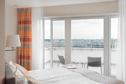 a bedroom with a bed and a large window at Green Loft Gdynia in Gdynia