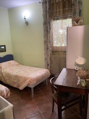 a bedroom with a table and a bed and a table sidx sidx sidx at B&B Villa Giardini Susanna in Veruno