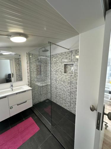 a bathroom with a glass shower and a sink at Madalena House in Madalena do Mar