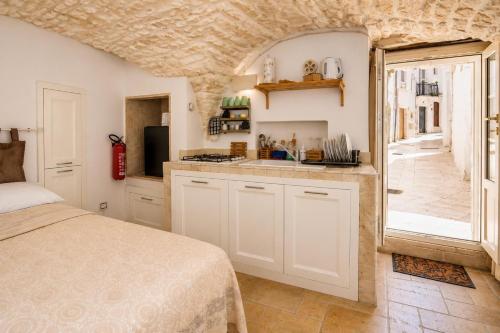 a kitchen with a bed and a sink in a room at Martine Dimore Storiche di Puglia in Martina Franca
