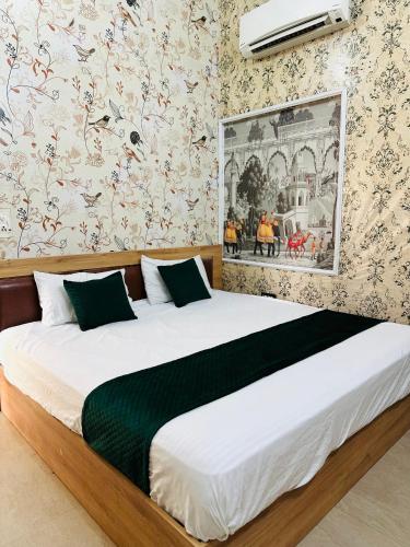 a bedroom with a large bed in a room with wallpaper at Hotel park view in Bathinda