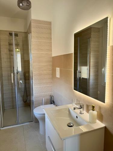 a bathroom with a sink and a toilet and a mirror at Trapani Urban Nest in Trapani