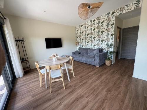 a living room with a table and a couch at L'Orée Lodge in Montcornet