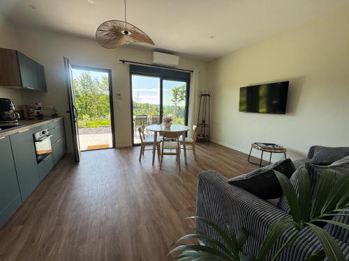a living room with a couch and a table with chairs at L'Orée Lodge in Montcornet