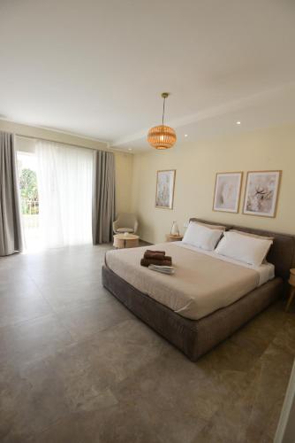 a large bedroom with a large bed and a chandelier at KY Orange Grove in Kerċem