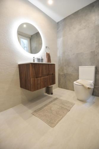 a bathroom with a sink and a toilet and a mirror at KY Orange Grove in Kerċem