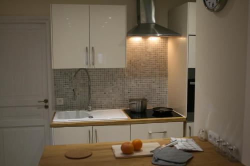 a kitchen with a counter with oranges on a cutting board at Apartment Lisa Acropolis Garibaldi in Nice