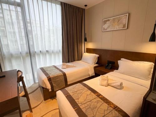 a hotel room with two beds and a window at Bliss Palace Hotel & Spa in Skopje