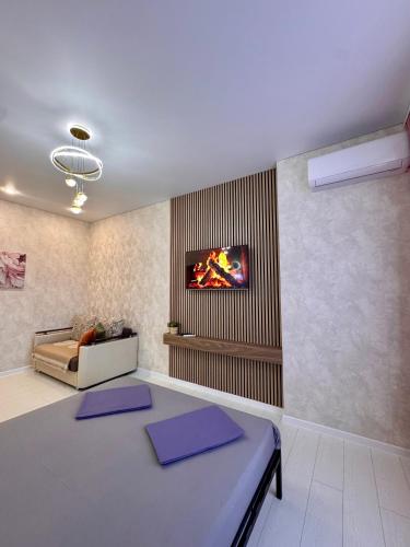 a living room with a table and a tv on the wall at A-Six Apartment, ЖК Достар 26 in Karagandy