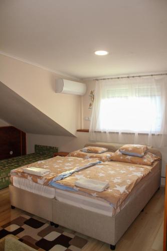 a large bed in a room with a window at Cserki Panzió Balatonfőkajár in Balatonfőkajár