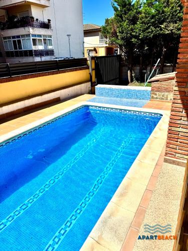 a swimming pool with blue water in front of a building at APARTBEACH BLAU MAR y PORT AVENTURA in Salou