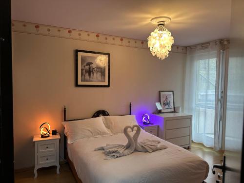 a bedroom with a bed with a swan on it at Hyper centre - Balcon / Parking in Le Havre