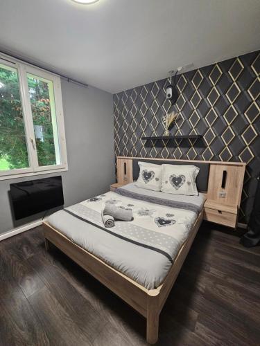 a bedroom with a large bed and a tv at Maison du Château d'eau Proche Disney, Parc Astérix, CDG, Paris, Parc des exposition in Mitry-Mory