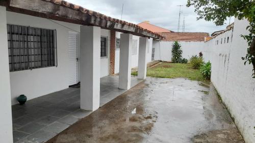 an empty courtyard of a white building with columns at Casa com 3 quartos in Itu