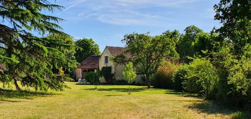 an old house in a yard with a tree at Ecurie Piaffe & Cie in Lurais