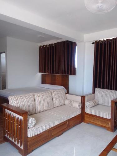 a bedroom with a bed and two couches at Be Cool in Aturugiriya