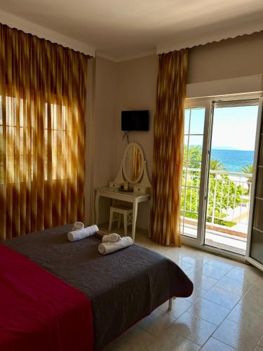 a bedroom with a bed and a view of the ocean at Asprovalta Rooms in Asprovalta