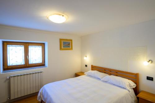 a bedroom with a white bed and a window at Casa Flory in Verbania