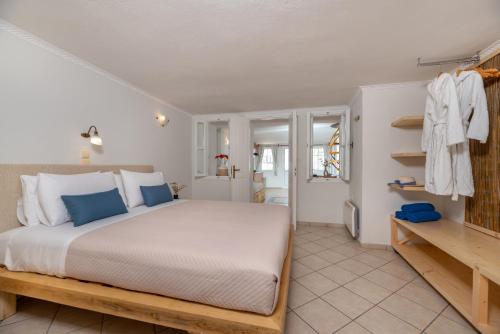 a bedroom with a large bed with blue pillows at Villa by Hotel Thira in Fira