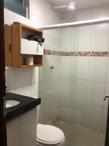 a bathroom with a toilet and a glass shower at Flats Olinda Vista Mar in Olinda