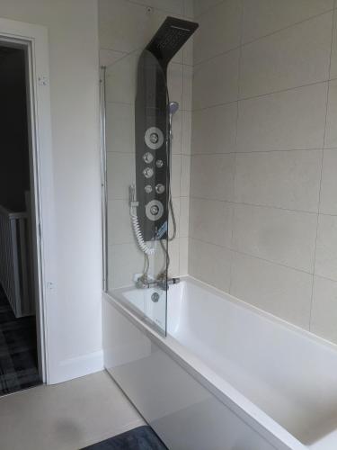 a shower in a bathroom with a phone on the wall at Hotel vibe at home in Edenderry