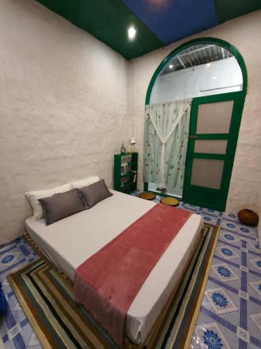 a bedroom with a bed and a green door at Homestay Nhà Có Gió in Thôn Mỹ Tường