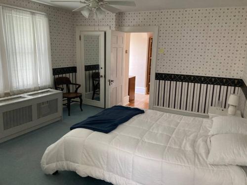 a bedroom with a large white bed and a window at Beach Block Victorian 1 minute from beach in Ventnor City