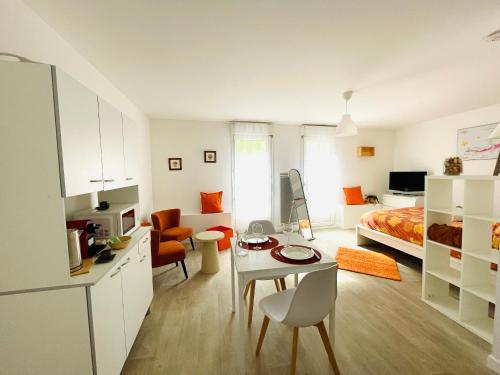 a room with a bed and a table and a kitchen at Hyper centre, rue piétonne, calme et lumineux in Dijon