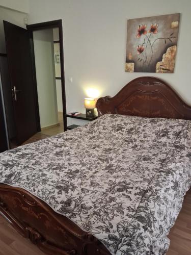 a bedroom with a wooden bed with a floral bedspread at TAKIS HOUSE in Káto Panayía