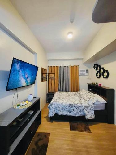 a bedroom with a bed and a flat screen tv at The Loop Towers Limketkai in Pontud