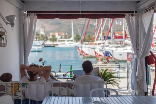 a group of people sitting at a restaurant looking at the water at Domus Maritima in Trogir