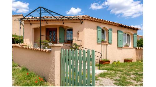 a house with a green fence in front of it at Gîte Valensole in Valensole