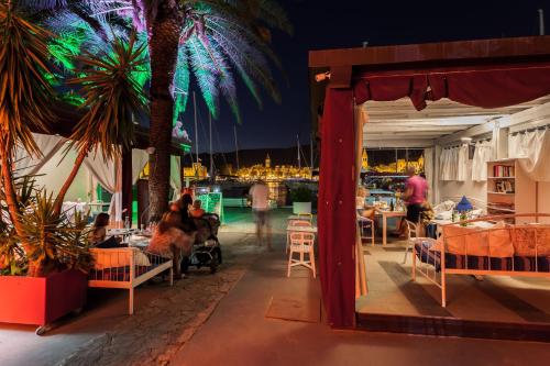 a group of people sitting on a patio at night at Domus Maritima in Trogir