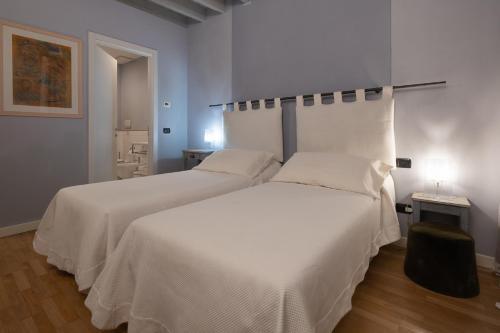 a bedroom with two beds with white sheets at B&B a Ca' Minore Franciacorta in Passirano