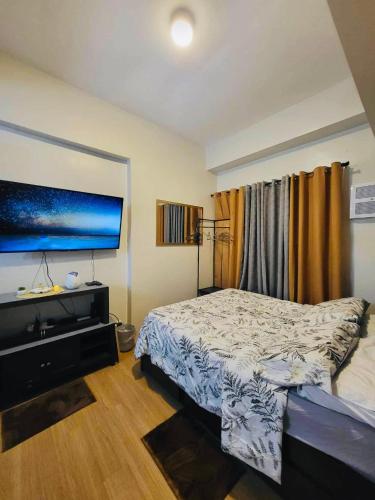 a bedroom with a bed and a flat screen tv at The Loop Towers Limketkai in Pontud