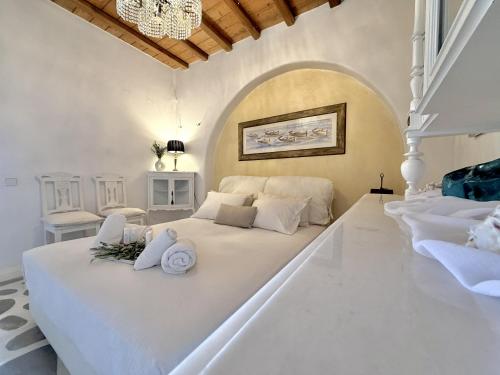 a white bedroom with a large bed with towels on it at Villa ELAYA in Mikonos