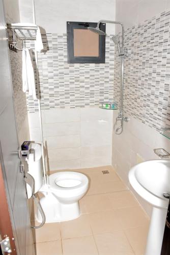 ein Badezimmer mit Toilette und Waschbecken in der Unterkunft Le Feto 3 in Dakar