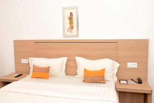 ein Schlafzimmer mit einem großen Bett und orangefarbenen und weißen Kissen in der Unterkunft Le Feto 3 in Dakar