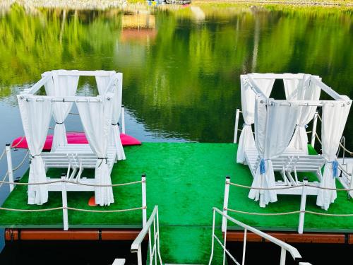 two chairs sitting on a boat in the water at Leo Green House in Cinciş