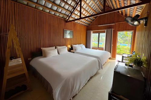 a bedroom with two beds and a flat screen tv at Tràng An Valley Garden in Ninh Binh